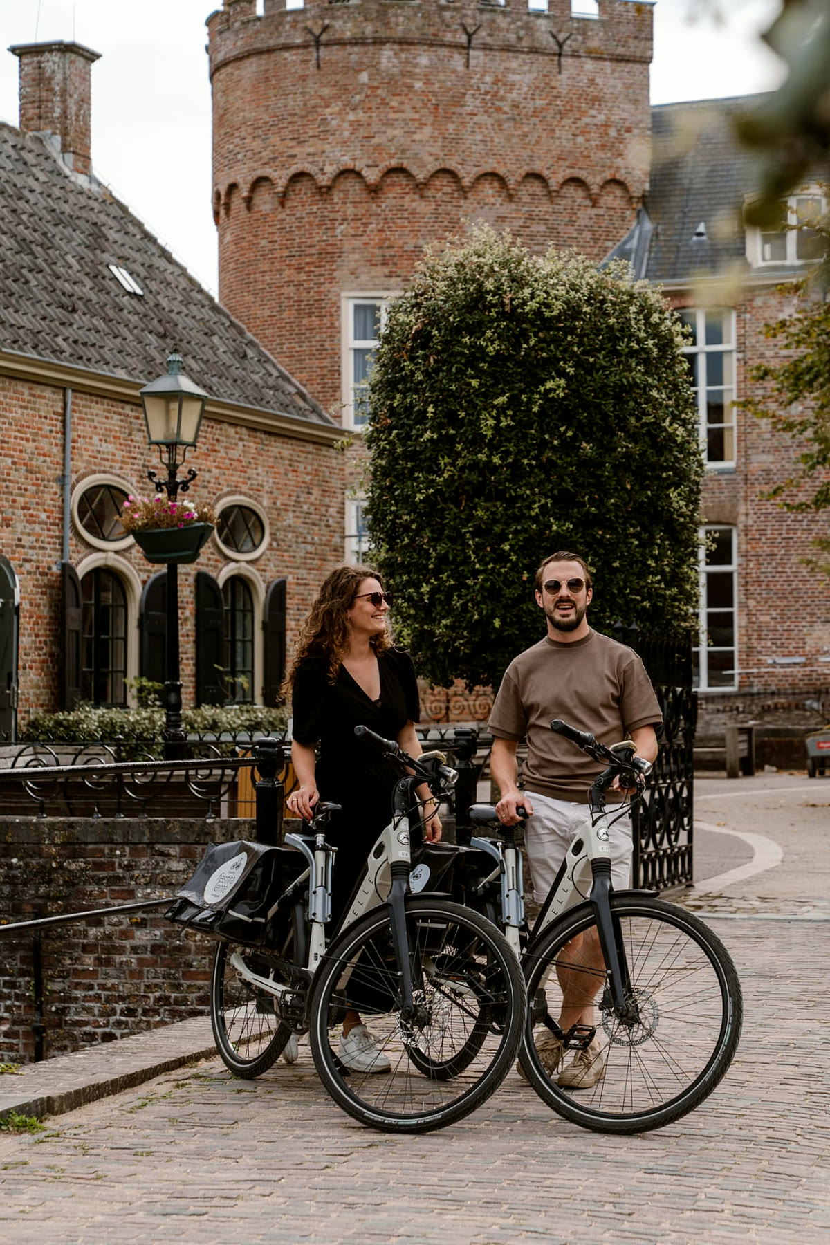 Twee gasten met Hello Bikes-huurfietsen in een Zeeuws dorp