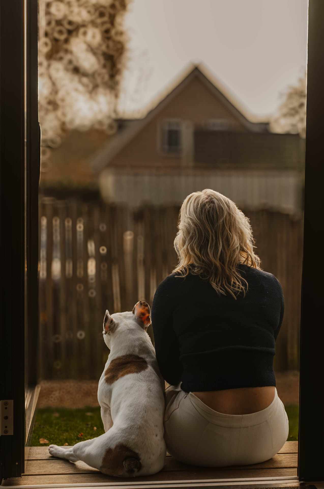 Vrouw met hond in de deuropening van een lodge