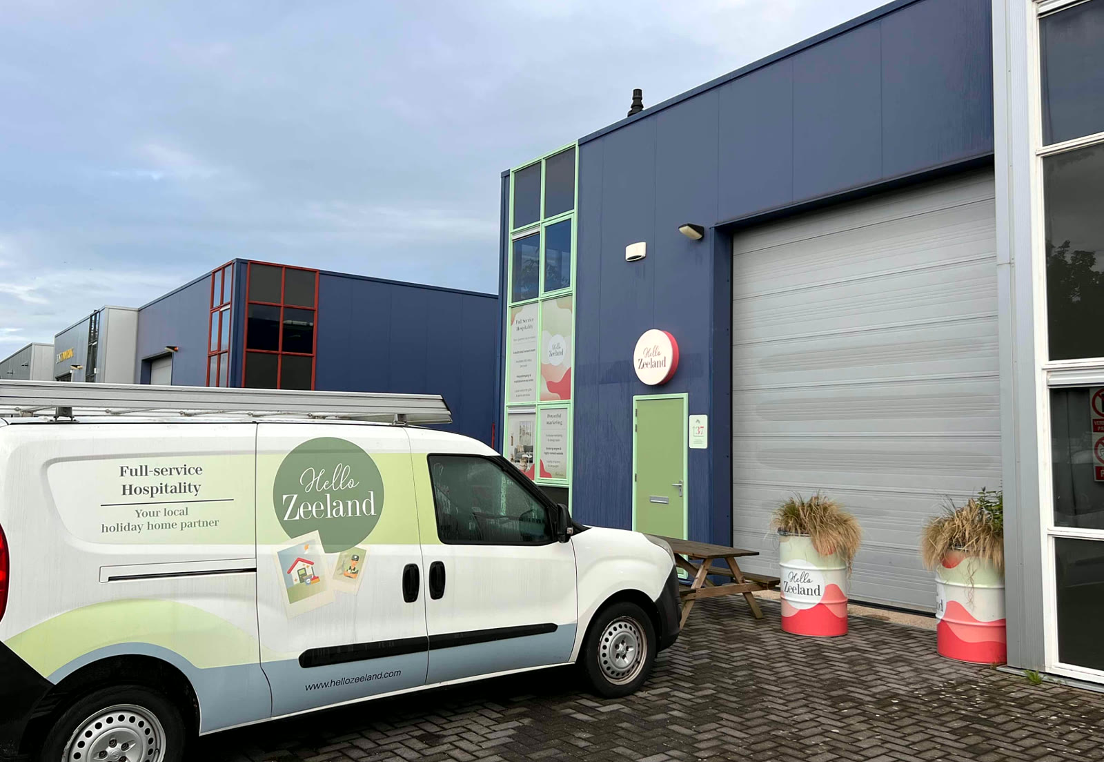 Bedrijfsbus met Hello Zeeland-belettering voor het kantoor in Serooskerke