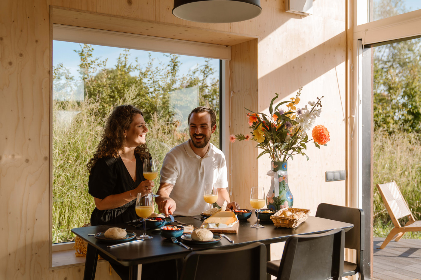 Gasten aan tafel in een tiny house in Zeeland